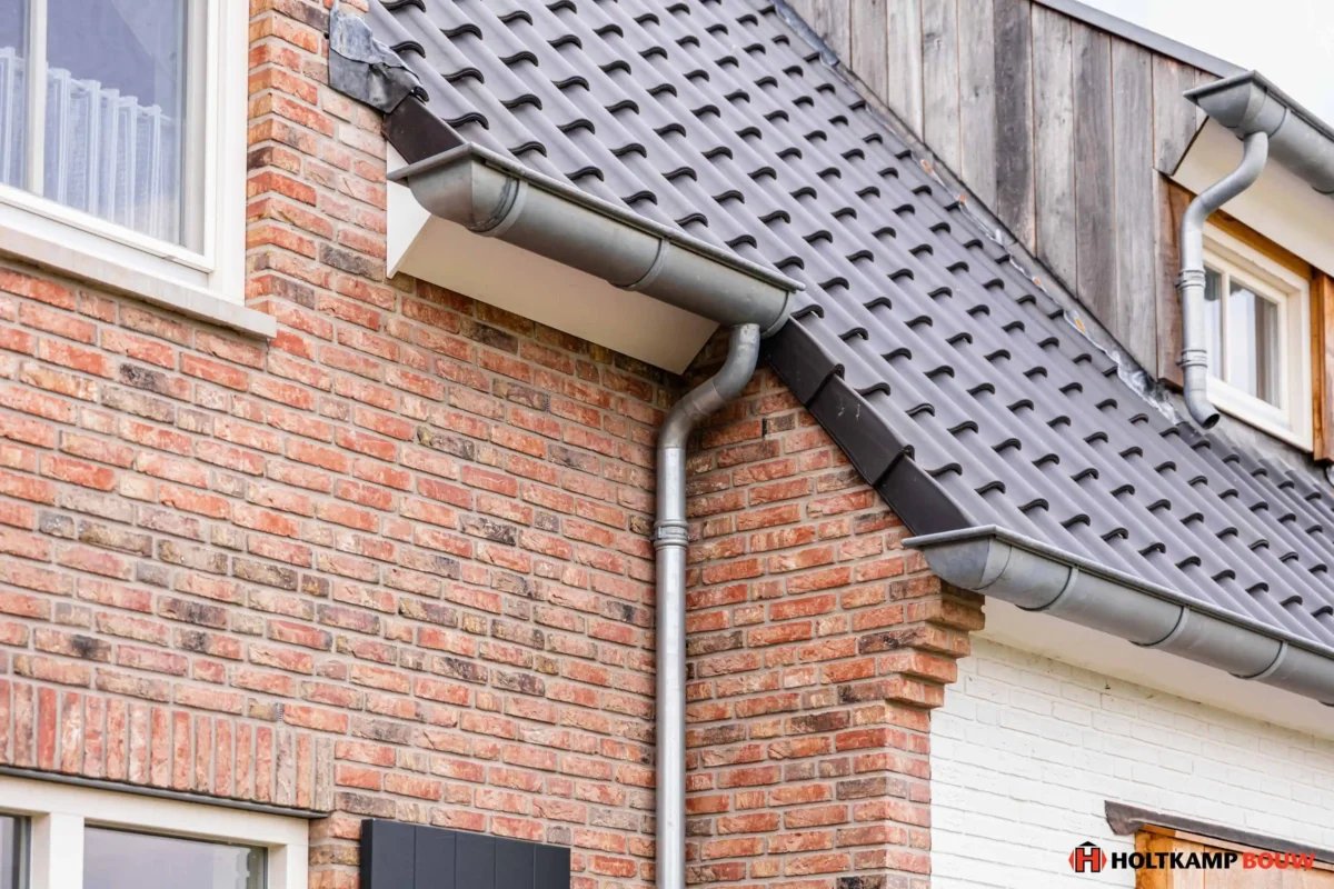 Zijaanzicht van de woning met zicht op de natuurlijke bakstenen en houten gevelafwerking