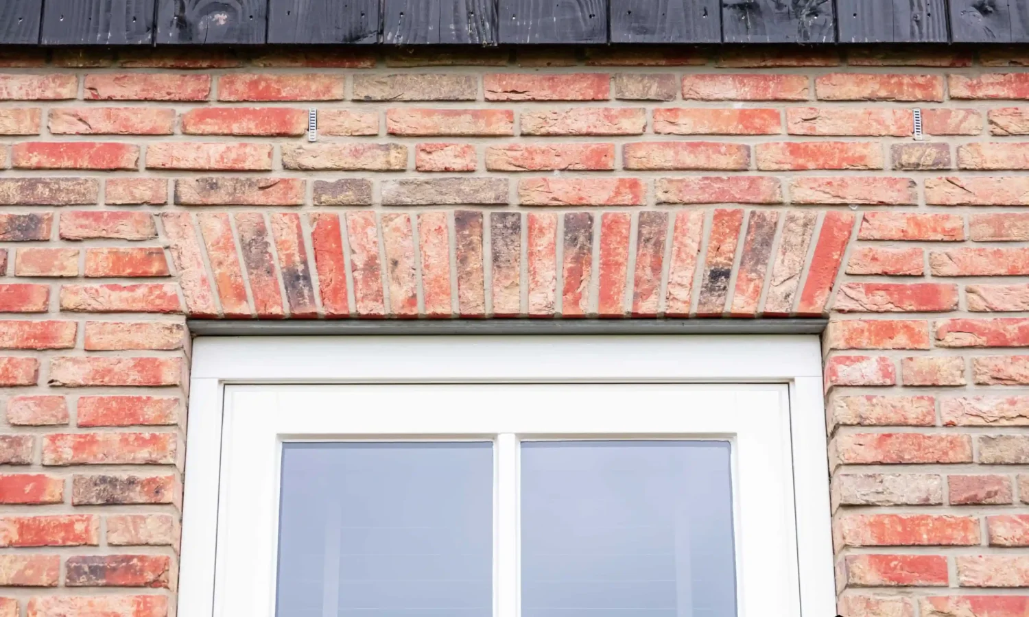 Zinken regenpijp met bladvanger als duurzaam detail bij schuurwoning, Holtkamp Bouw