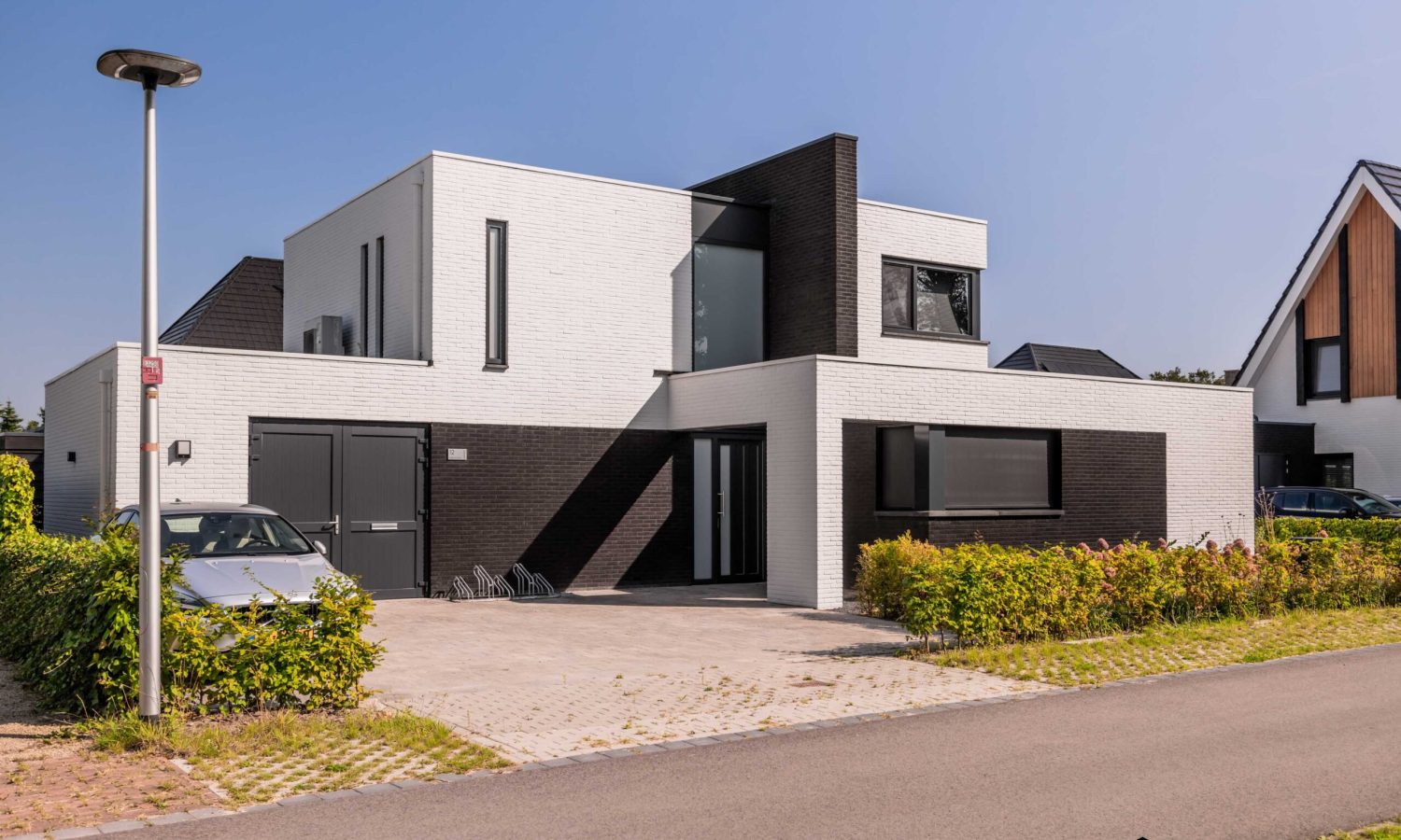 Breedte gesitueerde villa met wit gesausde gevel in wildverband