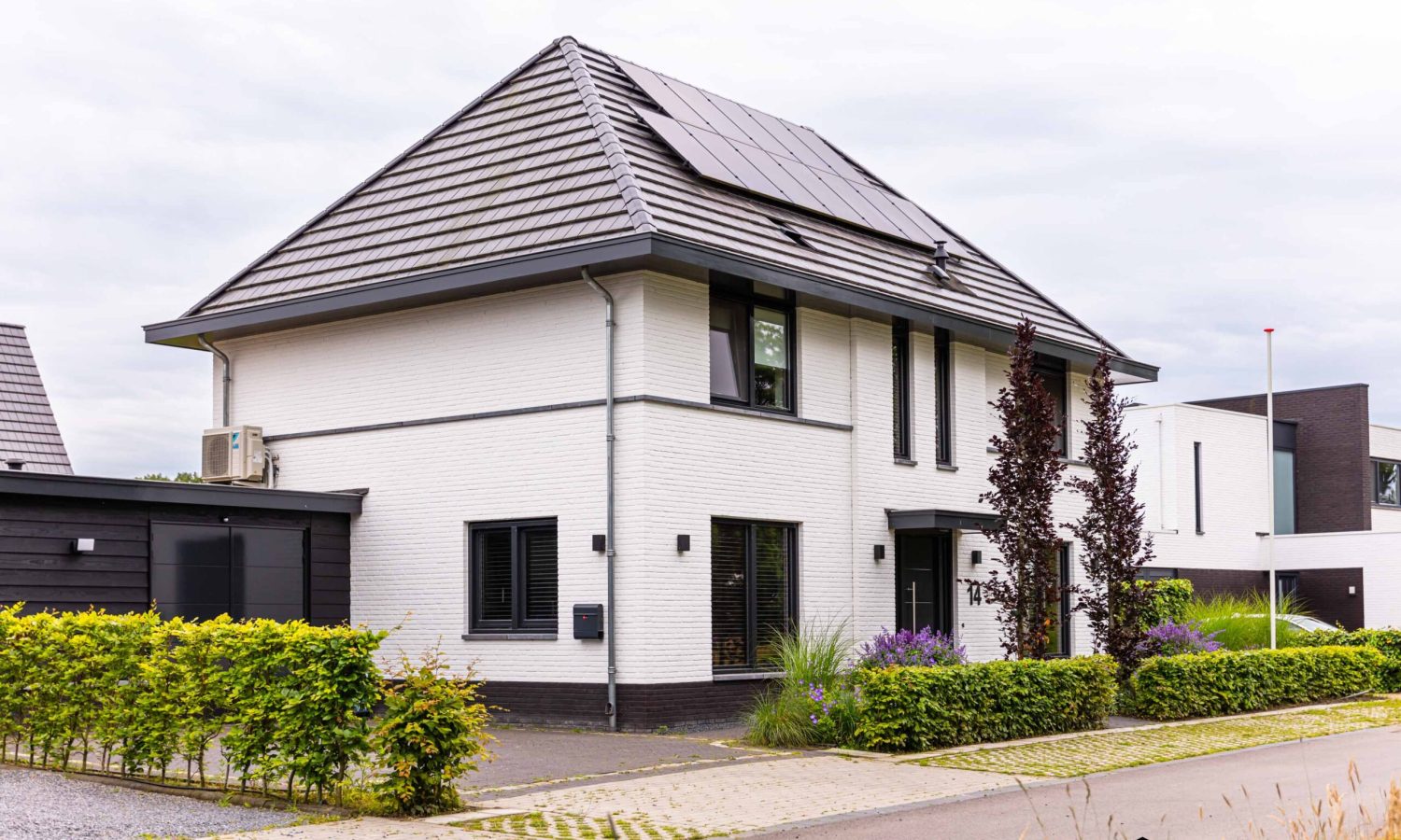 Zijaanzicht van een notariswoning in Hengelo, voorzien van Douglas Zweeds rabat en antraciet zwarte kozijnen (RAL 9021). Dak afgewerkt met vlakke keramische dakpannen in zwart/grijs.