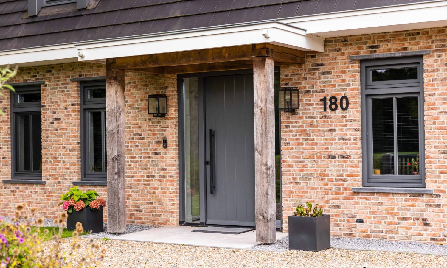 Voorzijde villa met luifel boven de voordeur en getimmerde bakgoot, ontworpen door Holtkamp Bouw