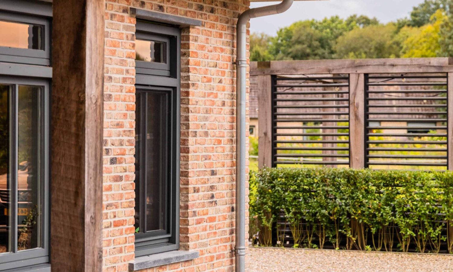 Moderne architectuur met strakke lijnen en antraciet zwarte kozijnen, gerealiseerd door Holtkamp Bouw