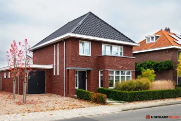 Breedte gesitueerde woning in Haaksbergen met moderne architectuur en getimmerde bakgoot, Holtkamp Bouw