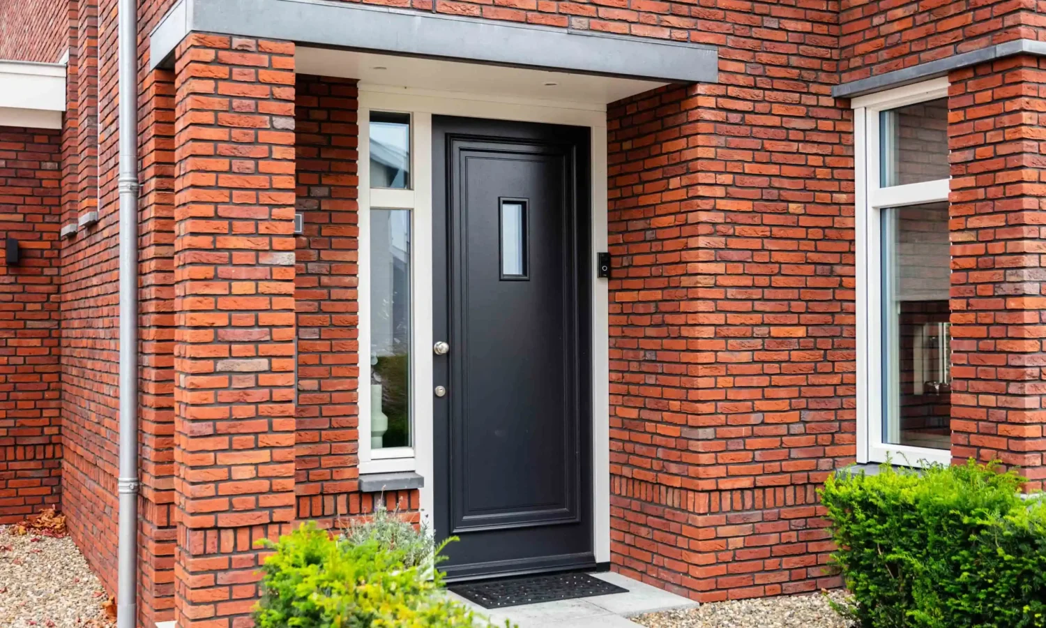 Close-up van getimmerde bakgoot en stijlvolle entree bij moderne woning, Holtkamp Bouw