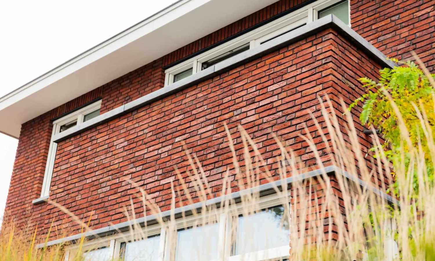 Strakke gevelafwerking met moderne details en getimmerde bakgoot, Holtkamp Bouw