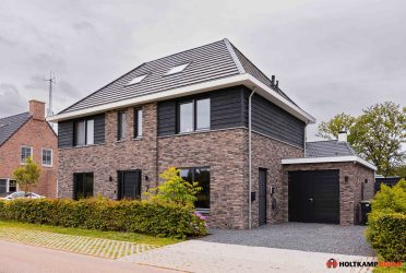 Moderne notariswoning met bakstenen gevel en zonnepanelen op het dak – een uniek ontwerp van Holtkamp Bouw.
