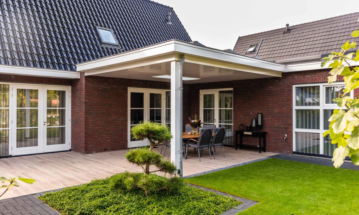 Detail van breedte gesitueerde villa met strakke lijnen en entree portaal, Holtkamp Bouw