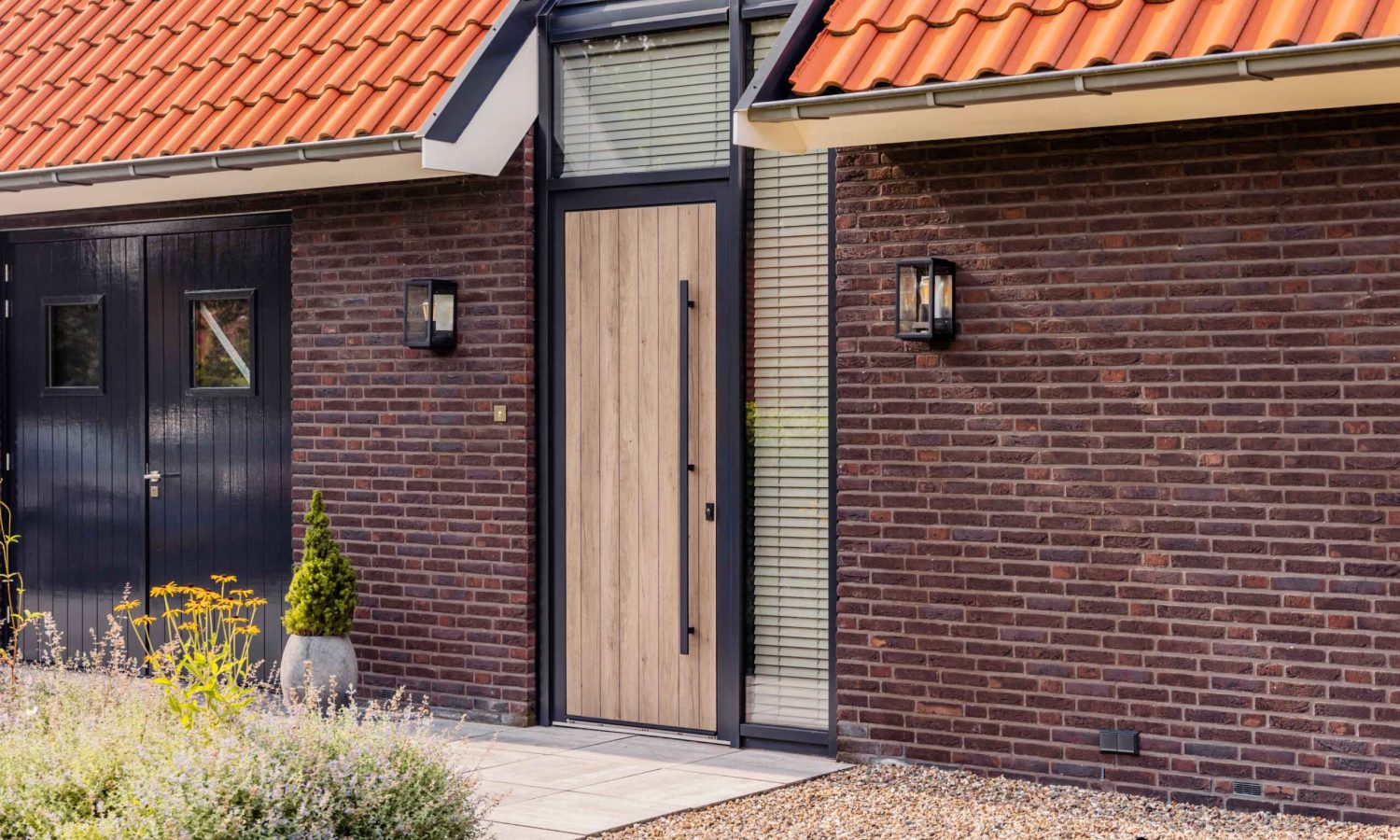 Architectonisch detail van moderne schuurwoning met zinken regenpijp en bladvanger, Holtkamp Bouw