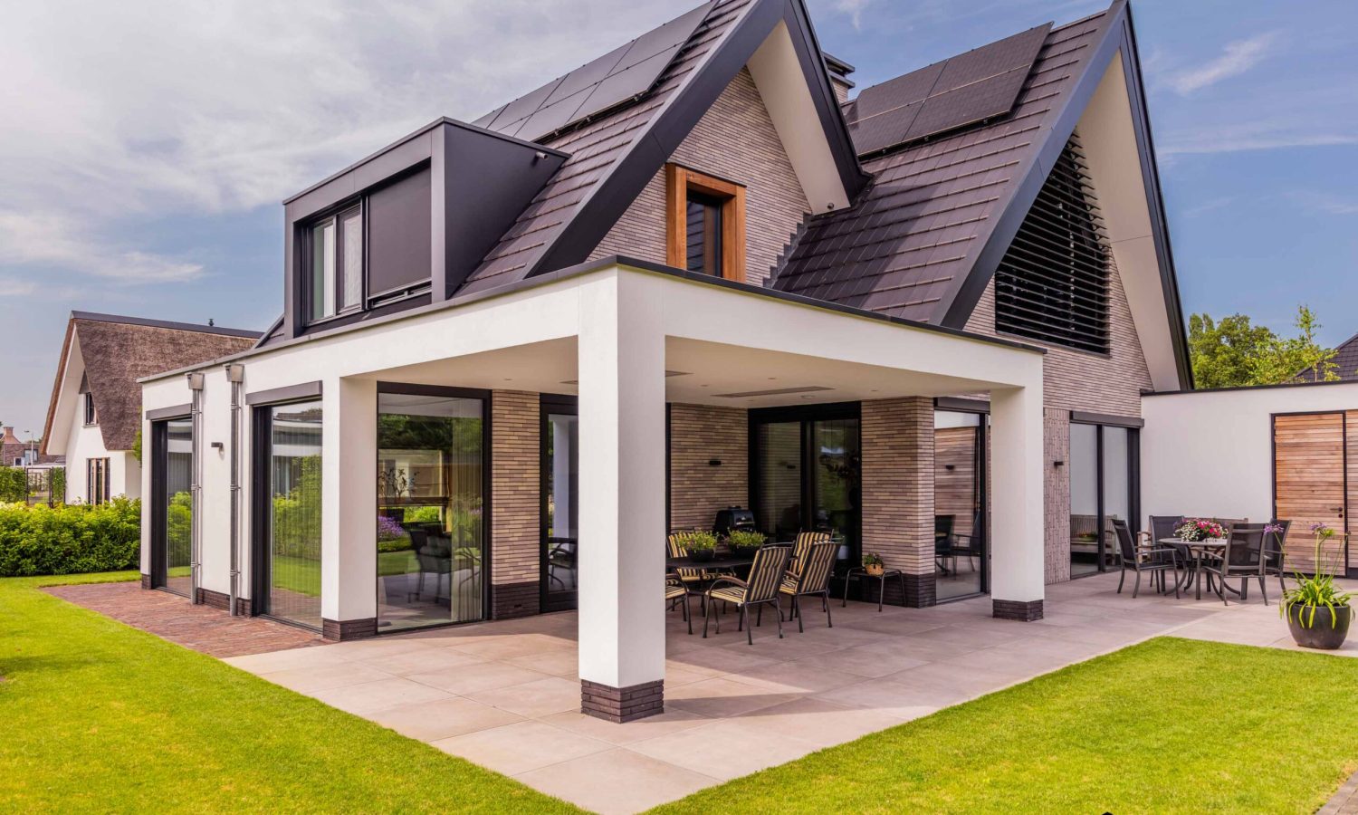 Detail van zinken regenpijp met bladvanger bij schuurwoning met antraciet zwarte kozijnen, Holtkamp Bouw