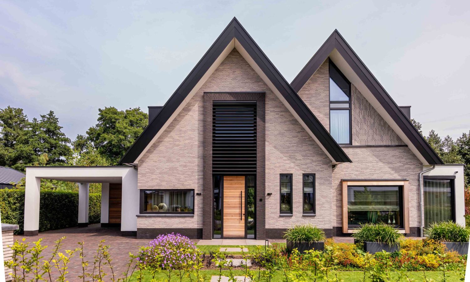 Moderne schuurwoning met antraciet zwarte kozijnen (RAL 9021) en natuurlijke houtkleur, breedte gesitueerd door Holtkamp Bouw