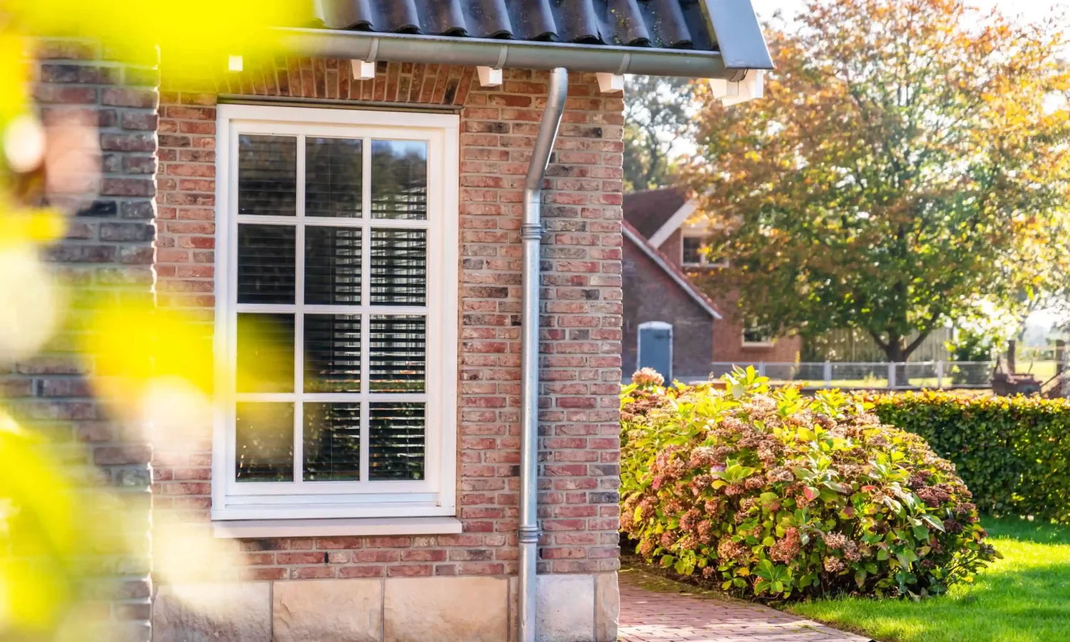 Zinken regenpijp met bladvanger als duurzaam detail bij schuurwoning, Holtkamp Bouw