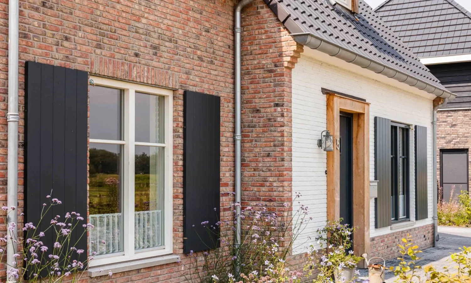 Achtertuin met open terras en grote raampartijen, die veel natuurlijk licht binnenlaten