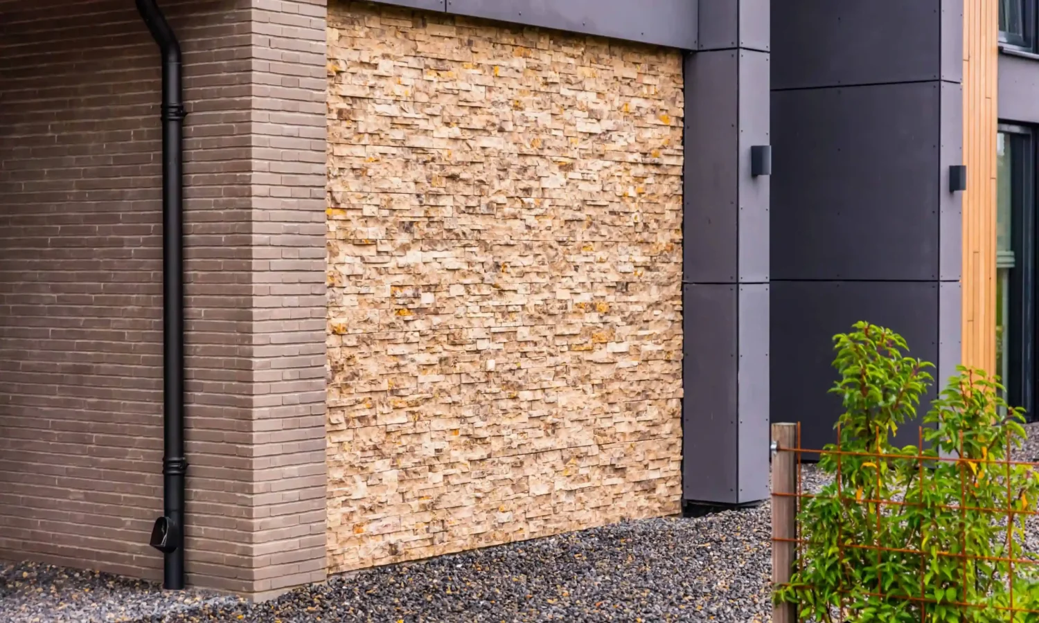 etail van een moderne gevel met een mix van natuursteen en donkergrijze gevelbekleding