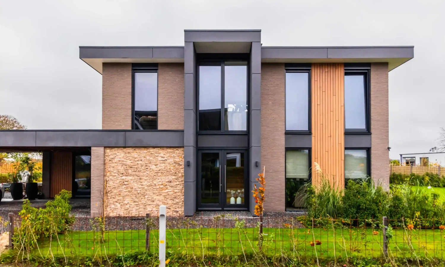 Vooraanzicht van een exclusieve woning met Siberisch Larix hout en grote raampartijen
