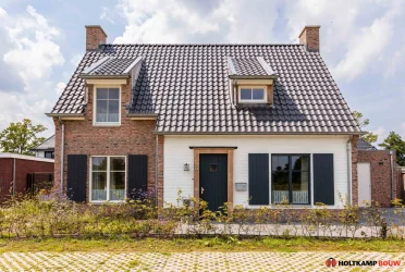 Voorgevel van een eigentijdse vrijstaande woning met natuurlijke houtkleurige accenten, ontworpen door Holtkamp Bouw in Hengelo
