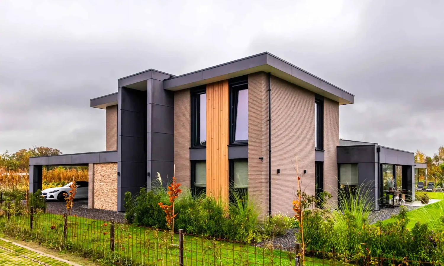 Luxe woning met een combinatie van steen, hout en zwarte gevelbekleding