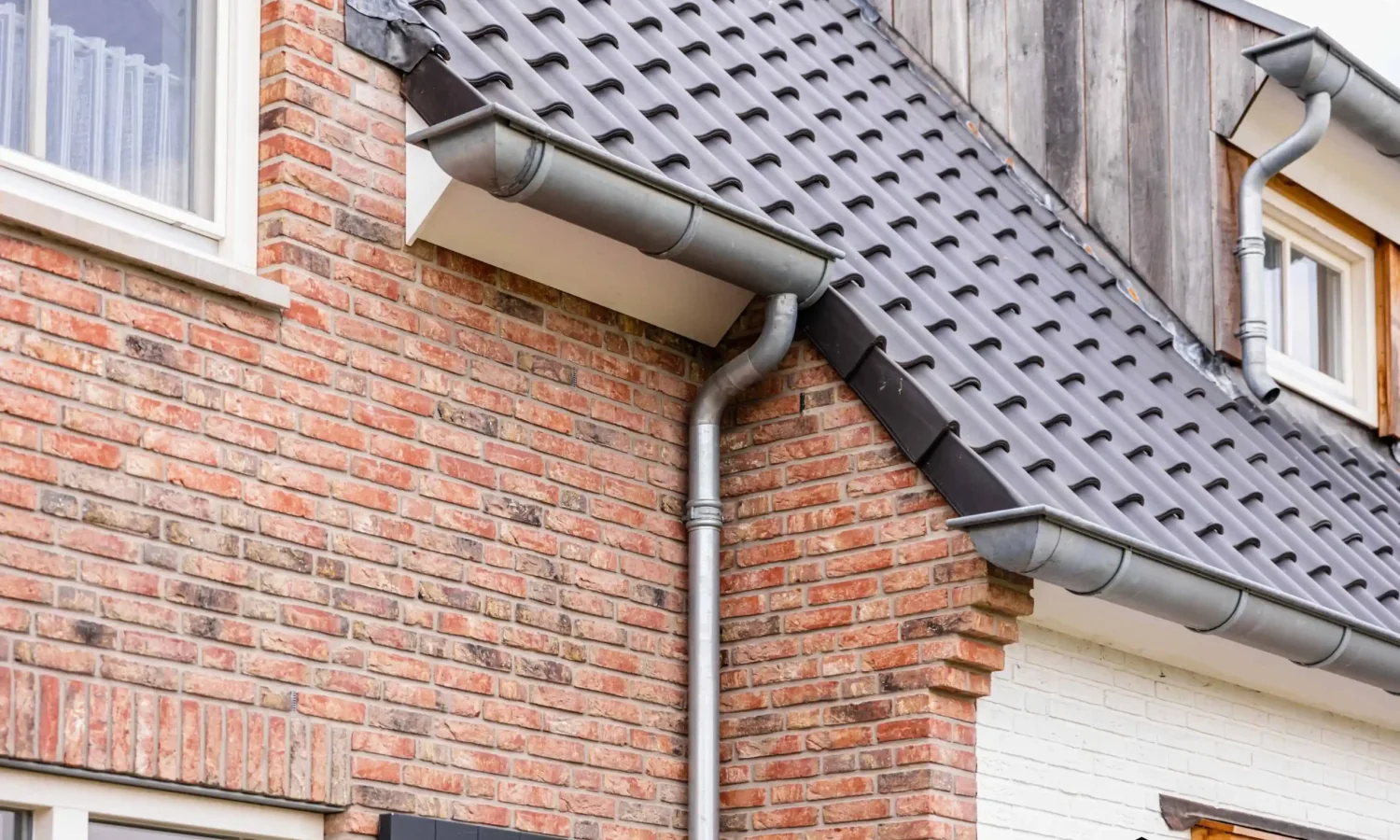 Zijaanzicht van de woning met zicht op de natuurlijke bakstenen en houten gevelafwerking