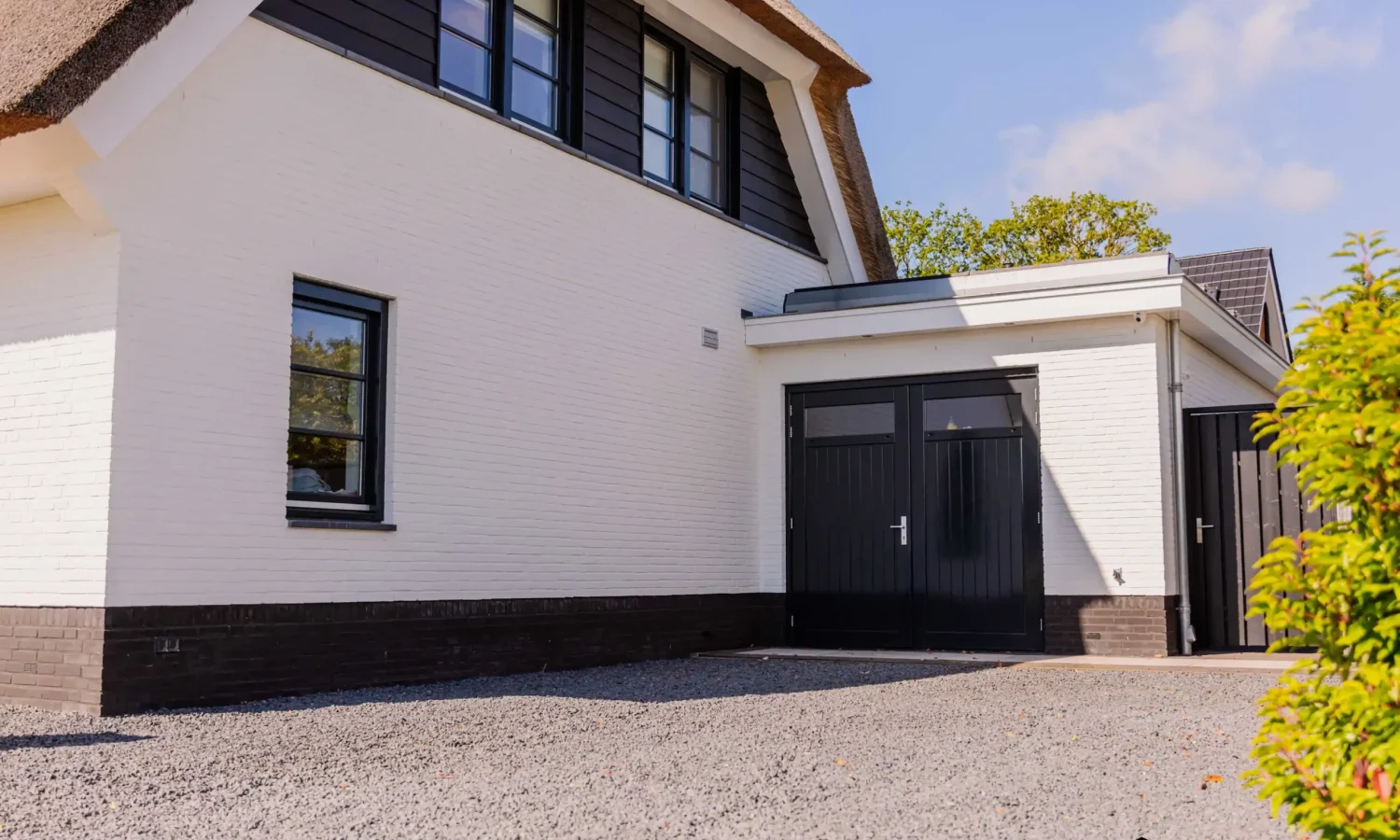 Zijkant witte rietgedekte villa